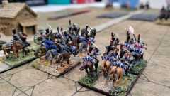 Les cuirassiers Français traversent un village au galop.